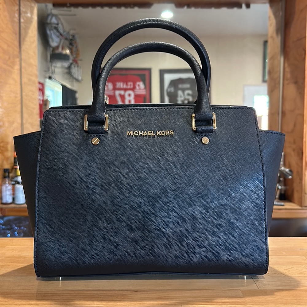 NEW! Authentic Michael Kors “Selma” handbag in black leather with gold hardware.
